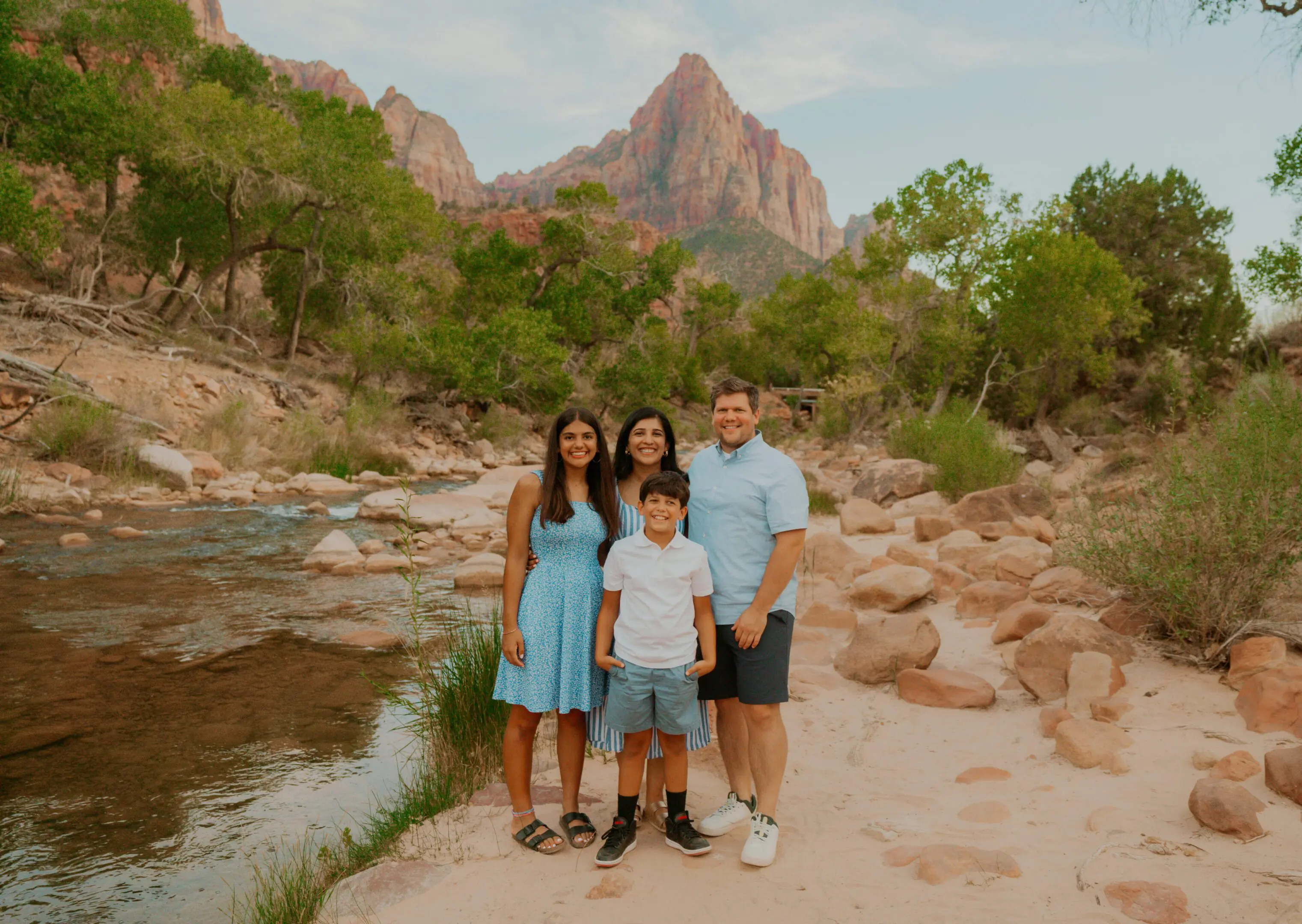 Family posing in scenic mountain landscape.